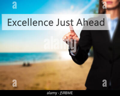 Excellence Just Ahead - Businesswoman hand pressing button on touch screen interface. Business, technology, internet concept. Stock Photo Stock Photo