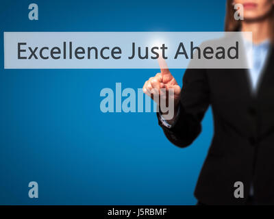 Excellence Just Ahead - Businesswoman hand pressing button on touch screen interface. Business, technology, internet concept. Stock Photo Stock Photo