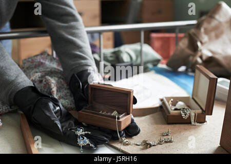 Burglar Stealing Items From Bedroom During House Break In Stock Photo