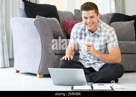 Portrait Of Male Freelance Worker Using Laptop At Home Stock Photo