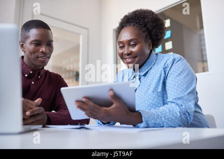 Young African coworkers using a digital tablet in an office Stock Photo