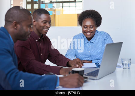 Content African business team working on a laptop together Stock Photo