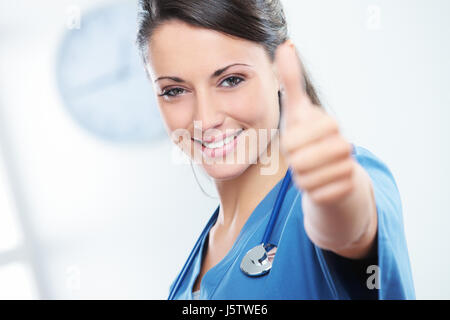 Young female doctor gesturing with thumbs up Stock Photo