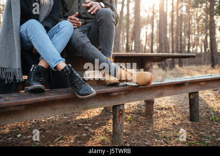Cropped image of loving couple sitting outdoors in the forest. Stock Photo