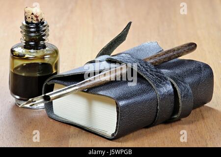 old fashioned diary with dib pen and inkwell on desktop Stock Photo