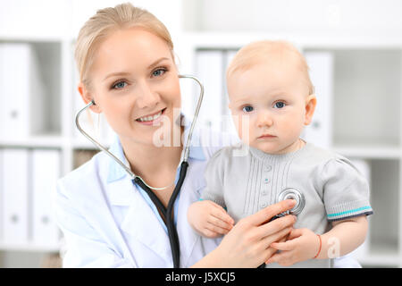 Pediatrician is taking care of baby in hospital. Little girl is being examine by doctor with stethoscope Stock Photo