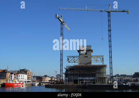 building crane waterfront antwerp large construction site sailing boat sailboat Stock Photo