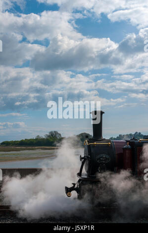 Locomotive in steam on a sunny day at Porthmadog with fluffy clouds. Stock Photo