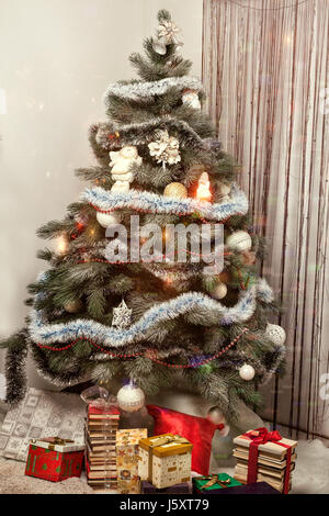 Christmas fir tree decorated with balloons and is sprinkled with snow ...