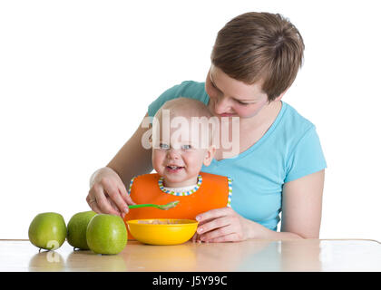Mother spoon-feeding her baby isolated on white Stock Photo