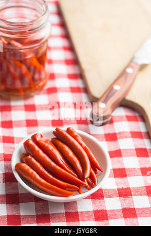 Pickled chili peppers in white bowl. Stock Photo