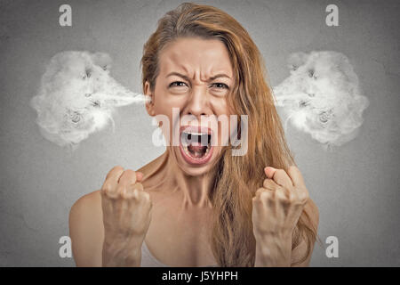 Closeup portrait angry young woman blowing steam coming out of ears, having nervous atomic breakdown, screaming isolated grey wall background. Negativ Stock Photo