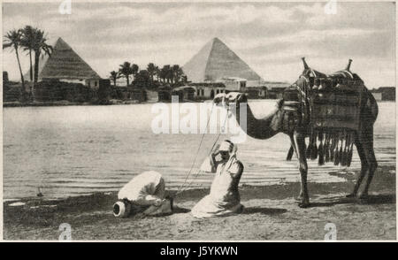 Morning Prayer along Nile River with Pyramids in Background, Cairo, Egypt, 1939 Stock Photo