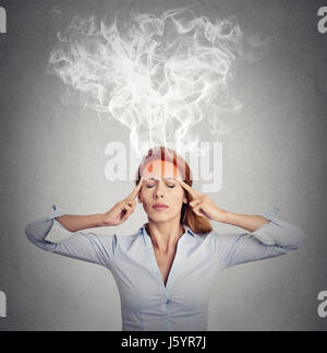 Portrait young woman thinking too hard steam coming out up of head isolated on grey wall background. Face expression emotion perception Stock Photo