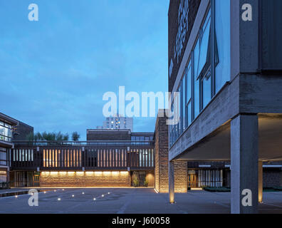 Exterior view within courtyard at dusk. Baylis Old school, London, United Kingdom. Architect: Conran and Partners, 1960. Stock Photo