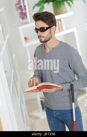 Man with sight impairment reading braille book Stock Photo