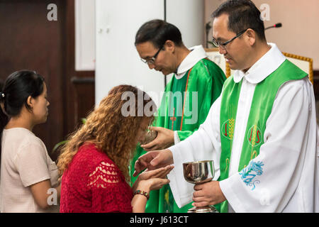 Catholic priests giving communion, Yinchuan, Ningxia, China Stock Photo