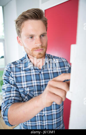 Young man entering code on indoor panel Stock Photo