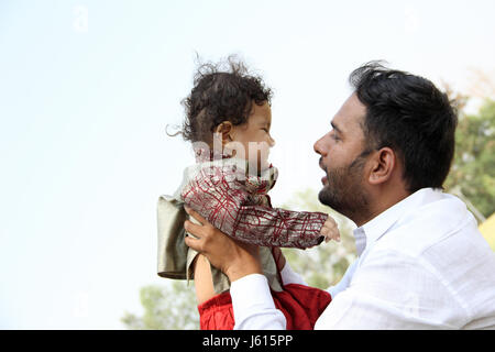 Young Indian father playing with his toddler holding him in his hands Stock Photo