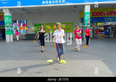 SHENZHEN, CHINA- MAY 11, 2017: An unidentified old people are training a choreography using sticks in outdoors and enjoying the time with their friends Stock Photo