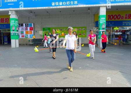 SHENZHEN, CHINA- MAY 11, 2017: An unidentified old people are training a choreography using sticks in outdoors and enjoying the time with their friends Stock Photo