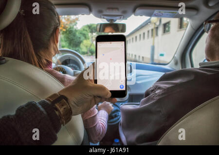 Girl driving with elderly man next to, receiving instructions from the gps phone Stock Photo