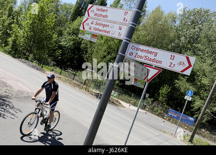Wuppertal, Germany. 17th May, 2017. A cyclist rides along the Nordbahn street and passes by road signs for cyclists in Wuppertal, Germany, 17 May 2017. The Cyclists' Association ADFC (Public German Bicycle Club) will make public a ranking of the most bicycle-friendly cities and communities in Germany on 19 May 2017. Photo: Oliver Berg/dpa/Alamy Live News Stock Photo