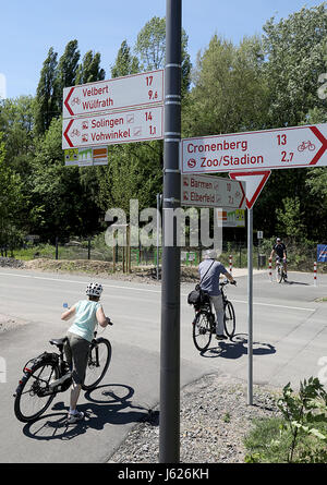 Wuppertal, Germany. 17th May, 2017. A cyclist rides along the Nordbahn street and passes by road signs for cyclists in Wuppertal, Germany, 17 May 2017. The Cyclists' Association ADFC (Public German Bicycle Club) will make public a ranking of the most bicycle-friendly cities and communities in Germany on 19 May 2017. Photo: Oliver Berg/dpa/Alamy Live News Stock Photo