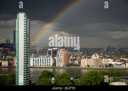 London, UK. 19th May, 2017. UK Weather: Colourful rainbow breaks during an evening rainstorm over the River Thames and riverside apartments. © Guy Corbishley/Alamy Live News Stock Photo