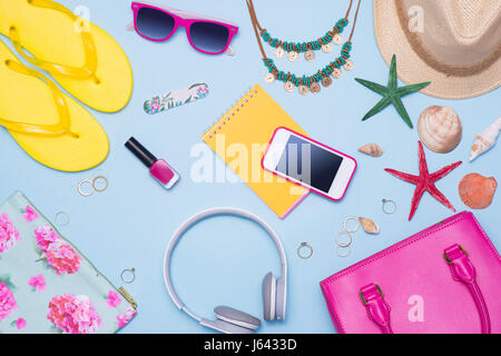 Summer concept. Pink handbag with accessories on light blue background Stock Photo