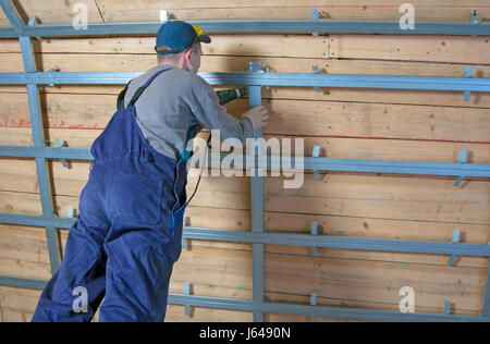 Man assembles profile metal frame for plasterboard ceilings Stock Photo