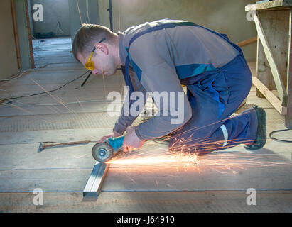 man assembles profile metal frame for plasterboard ceilings Stock Photo