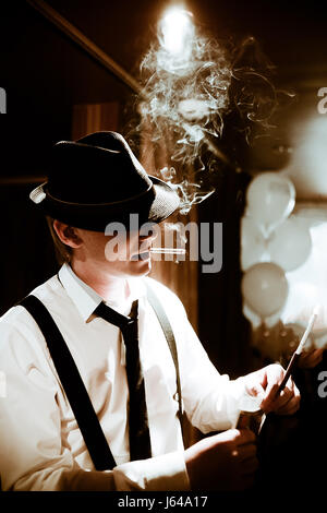 Mobsters sitting and smoking a cigar through smoke Stock Photo