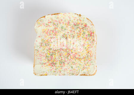 a quirky icing birthday bread covered with sprinkles on white background Stock Photo