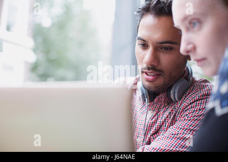 Focused young men using laptop in cafe Stock Photo
