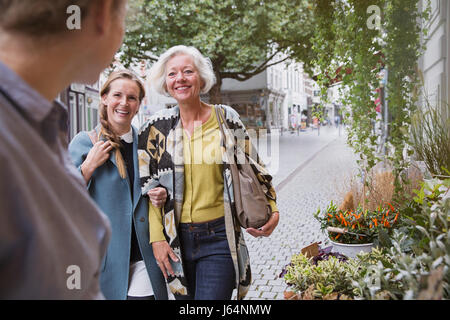 Mother and daughter smiling at florist at storefront Stock Photo
