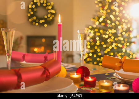 Candles, champagne and Christmas crackers on table Stock Photo