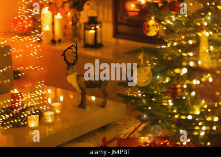 Reindeer decoration in ambient living room with candles and Christmas tree Stock Photo