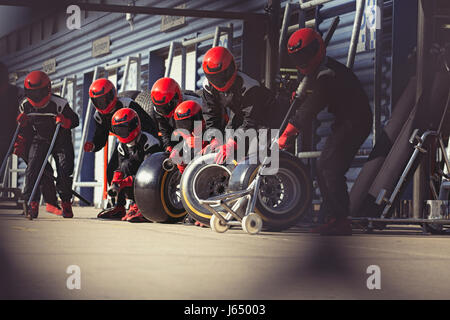 Pit crew preparing tires in formula one pit lane Stock Photo