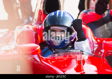 Formula one race car driver in helmet gesturing, celebrating victory Stock Photo