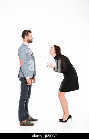 Image of offended young loving couple swear isolated over white background. Looking aside. Stock Photo