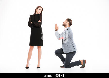 Image of offended young loving couple standing isolated over white background. Looking aside. Man ask for apologize. Stock Photo