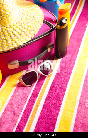 Colorful striped beach bag with a straw hat towel sunglasses and a ...