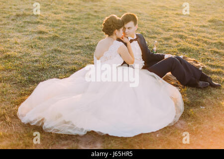 The above view of the sitting bride leaning on the groom during the picnic. Stock Photo