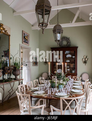Spacious dining area. The eighteenth-century mahogany table is laid with crystal and block-printed linen napkins. The chairs are antique from France a Stock Photo