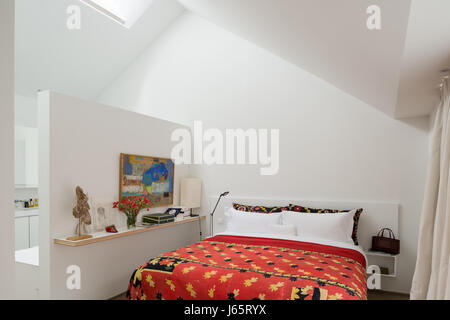 atelier Brussels A-frame roof with low diving wall to ensuite and red quilt from Dhaka Stock Photo