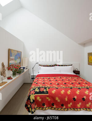 A-frame roof with low diving wall to ensuite and red quilt from Dhaka Stock Photo