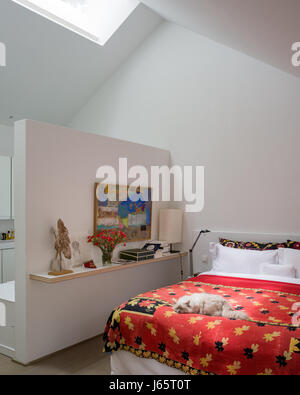 A-frame roof with low diving wall to ensuite and red quilt from Dhaka Stock Photo