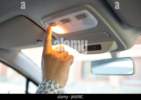Man turning on the light in the car in his car, close-up Stock Photo