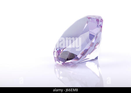 Purple crystal gem on a white surface. Purple crystal gem isolated on white background. Stock Photo